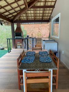a dining table with chairs and a grill on a patio at Chácara Vista da Mata in Marechal Floriano