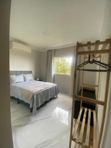 a bedroom with a bed and a ladder and a window at Chácara Vista da Mata in Marechal Floriano