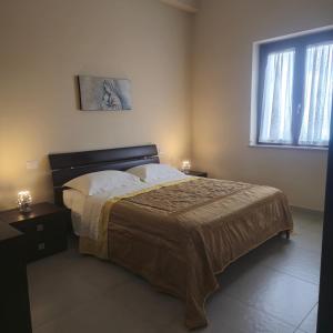 a bedroom with a large bed and a window at House le Ancore in Barcellona-Pozzo di Gotto