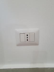 een witte lichtschakelaar op een witte muur bij House le Ancore in Barcellona-Pozzo di Gotto