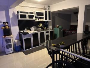 a kitchen with white cabinets and a black counter top at StayLOG Peradeniya in Kandy