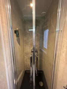 a shower with a glass door in a bathroom at Hotel West Inn Aan Zee in Den Oever