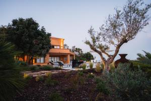 a house with a garden in front of it at Casa Pôr do Sal in Luz
