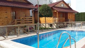 a swimming pool in front of a house at Cabañas de Madera El Rinconcillo in Arroyo Frio