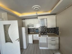 a kitchen with white cabinets and a white refrigerator at Espinaz Apart Otel in Bostaniçi