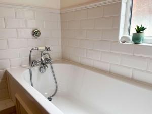 a white bath tub with a shower in a bathroom at Luxury 1 Bedroom Apartment in Southend w Parking in Southend-on-Sea