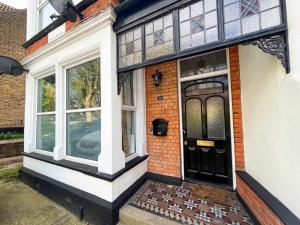 a brick house with a black door and windows at Luxury 1 Bedroom Apartment in Southend w Parking in Southend-on-Sea +19 photos