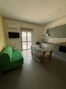 a living room with a table and a kitchen at La Rosa dello Jonio in Giarre +2 photos
