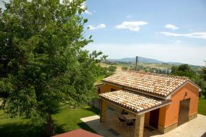 a small house with a table and chairs and a tree at Azienda Agrituristica Le Bucoliche in Osimo