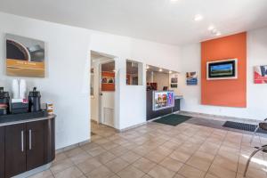 Habitación con paredes de color naranja y blanco. en Travelodge by Wyndham Lansing en Lansing