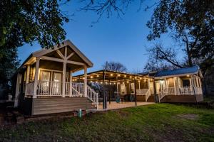 a home with a large porch and a house at Riverfront Tiny House with Fire Pit in Seguin, Texas in Seguin