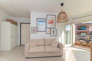 a living room with a couch and pictures on the wall at Alba Azzurra in San Pasquale +12 photos