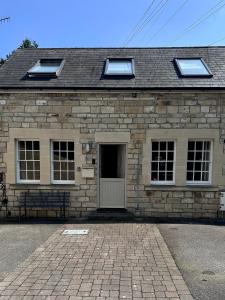 ein Steinhaus mit einer Tür und einer Bank davor in der Unterkunft Bath Central Free Parking One Double Ensuite Room in Historical Mews Cottage in Bath + 13 Fotos