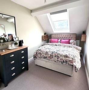 ein Schlafzimmer mit einem Bett, einer Kommode und einem Fenster in der Unterkunft Bath Central Free Parking One Double Ensuite Room in Historical Mews Cottage in Bath