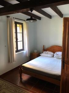a bedroom with a bed with white sheets and a window at Rose cottage in Montcaret