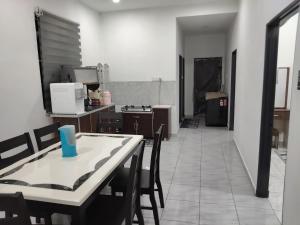 a kitchen with a table and chairs in a room at Tasmie homestay in Butterworth