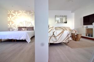 a white room with a bed and a tv at Villa Ocean 8 by Dreaming Lanzarote Villas in Yaiza