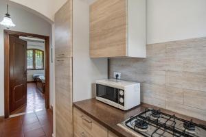 a kitchen with a microwave and a stove at Casa Rosmarino in Cisano sul Neva