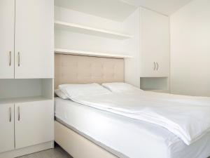 biała sypialnia z białymi szafkami i łóżkiem w obiekcie Apartment Marija-2 by Interhome w mieście Jurandvor
