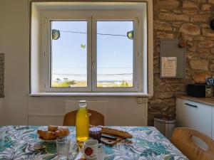 a table with a window and a plate of food on it at Holiday Home La Grande Roche - POD101 by Interhome in Porspoder