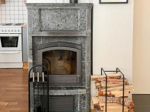 a stone fireplace in a living room next to a stove at Holiday Home Karhunvartijan linna a1 by Interhome in Ruka +5 photos