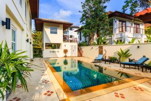 an image of a swimming pool in front of a house at Baan Kaja Villa by Lofty in Surin Beach