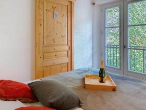 1 dormitorio con 1 cama y 1 botella de vino en Apartment Conseil 3 by Interhome, en Saint-Gervais-les-Bains