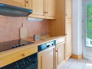 Una cocina con gabinetes de madera y un fregadero. en Apartment Conseil 3 by Interhome, en Saint-Gervais-les-Bains