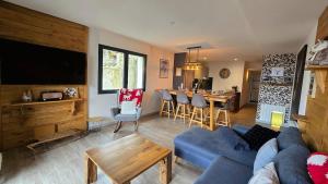 Una sala de estar con un sofá azul y una mesa. en Le Caribou La Mongie, en Bagnères-de-Bigorre