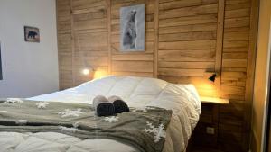 Una cama con dos pares de zapatos encima en Le Caribou La Mongie, en Bagnères-de-Bigorre