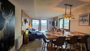 Un comedor y una sala de estar con mesa y sillas. en Le Caribou La Mongie, en Bagnères-de-Bigorre