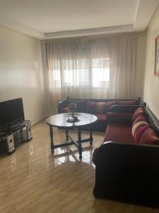 a living room with a couch and a table at Laziza in Temara