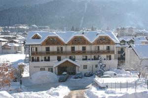 un grande edificio con la neve sopra di esso di Hotel Canada ad Andalo