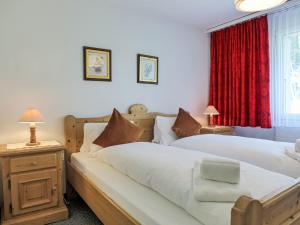 um quarto com duas camas e uma cortina vermelha em Apartment Chalet Wyssefluh by Interhome em Grindelwald