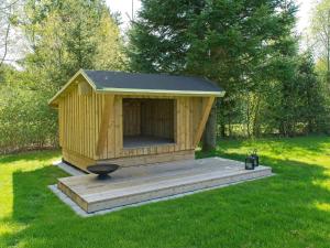 a dog house with a deck in the grass at Holiday Home Gardi - 14km from the sea by Interhome in Oksbøl +19 photos