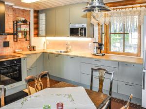 une cuisine avec une table, un évier et une cuisinière dans l'établissement Holiday Home Piilopirtti by Interhome, à Salonnenä