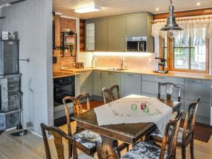 une cuisine avec une table en bois et une table et des chaises dans l'établissement Holiday Home Piilopirtti by Interhome, à Salonnenä