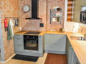 - une cuisine avec une cuisinière et un mur en briques dans l'établissement Holiday Home Piilopirtti by Interhome, à Salonnenä