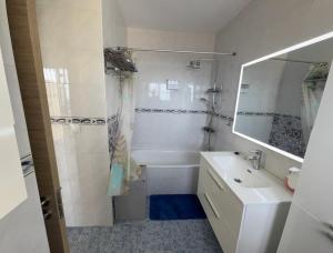 a bathroom with a tub and a sink and a mirror at Lujoso adosado familiar en la costa del sol in Benalmádena