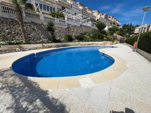 a large blue swimming pool next to a building at Lujoso adosado familiar en la costa del sol in Benalmádena
