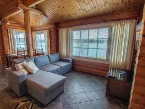 un salon avec un canapé et deux fenêtres dans l'établissement Holiday Home Iltarusko by Interhome, à Hara
