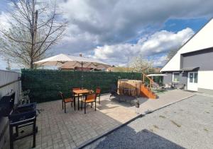 a patio with a table and chairs and an umbrella at SALT HOUSE Apartman in Gheorgheni