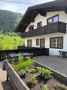 a house with a patio with a table and some plants at Ferienhaus Rotenbichler in Schladming