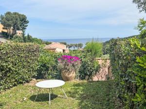 Holiday Home Village Cap Estérel - Le Hameau-36 by Interhome في Drammont: طاولة بيضاء في ساحة مليئة بالزهور +49 صورة