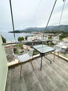a patio with a table and chairs on a balcony at Rooms with view in Himare