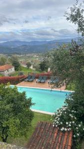 a swimming pool with blue water and lounge chairs at Casa das Andorinhas in Celorico de Basto