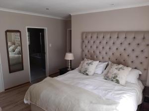 a bedroom with a large bed with a large headboard at Mountains and More in Hekpoort