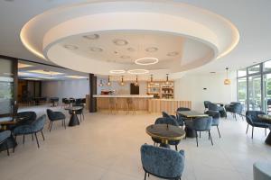a restaurant with tables and chairs and a large ceiling at AquaMed Hotel Harkány in Harkány +48 photos