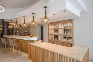 a kitchen with a bar with lights at AquaMed Hotel Harkány in Harkány