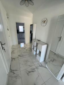 een kamer met een betegelde vloer en een klok aan de muur bij Maison 3chambres avec piscine in Istres +20 foto's